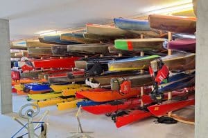 Viele bunte Kanus, gestapelt in einer Halle.