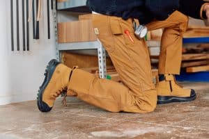 Arbeitshose in Braun, an einer Person auf Fußboden.