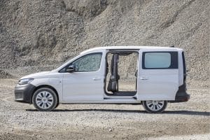 Weißer Transporter mit geöffneten Türen in einer Kiesgrube.