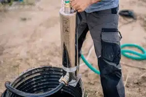 Mann schneidet Wasser schwarze Kabel zu.