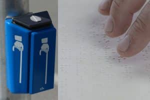 Barrierefreiheitsstärkungsgesetz: Ampelanlage mit Blindensignal und nebenan Blindenschrift auf weißem Papier mit einer Hand die darüber liest.