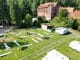 Campingplatz von oben mit Wohnwagen, Scheune und Wohnhaus im Grünen.