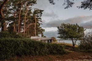Caravan unter Bäumen, am Strand in Rügen auf dem Wildwood Campingplatz.