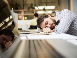 Boreout-Syndrom: Mann schläft am Arbeitsplatz.