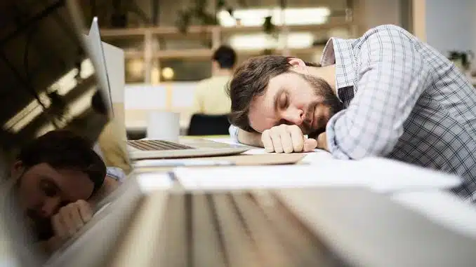 Boreout-Syndrom: Mann schläft am Arbeitsplatz.