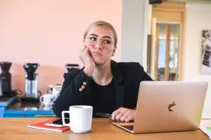 Boreout-Syndrom: Langeweile am Arbeitsplatz. Eine gelangweilte Frau am Laptop im Büro.