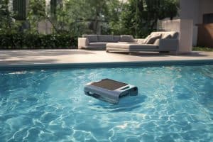 Neues Produkt: Aiper-Surfer-S2 Poolreiniger im Wasser eines Pools, daran grenzt eine Terrasse an.