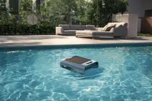 Neues Produkt: Aiper-Surfer-S2 Poolreiniger im Wasser eines Pools, daran grenzt eine Terrasse an.