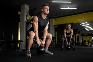 Mann beim Sport in einem Fitnessstudio, hebt ein Gewicht.