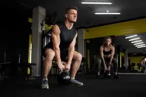 Mann beim Sport in einem Fitnessstudio, hebt ein Gewicht.