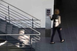 Frau verlässt während Pause das Gebäude und stempelt mit Karte aus. 
