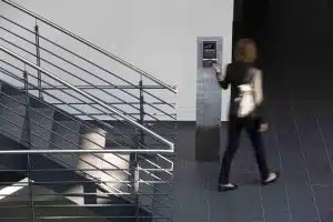 Frau verlässt während Pause das Gebäude und stempelt mit Karte aus. 