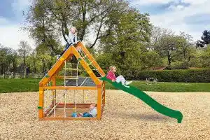 Spielhaus zum Klettern mit Rutsche auf einem Spielplatz.