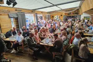 Viele Menschen an Tischen teilweise vor Laptop die dem Arbeitskreis Hotelimmobilien zuhören.